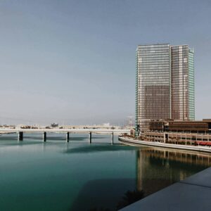 Elegant modern architecture in Abu Dhabi with clear sky reflecting on calm waters.